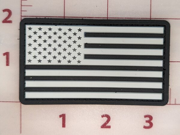 Black and white American flag patch with a rectangular border.